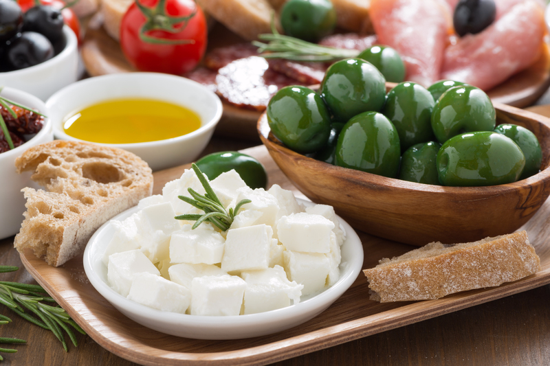 Food tray with bread, feta, olives and olive oil.