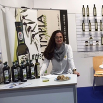 Maria Rotiri behind an exhibition stand, presenting Optima Feinkost's products